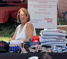 Lakeside Trading employee at a community merchandise table